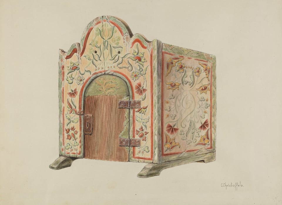 The image shows a small intricately decorated wooden structure with an arched top and a central door flanked by two metal hinges. The structure is painted with a floral and vine motif in colors such as red, green, and yellow on a light background. The wooden door has a textured appearance. The object is positioned centrally with the door facing forward, placed on a slightly elevated base with two footings extending forward. The overall look is ornate and symmetrical, showcasing detailed design work.