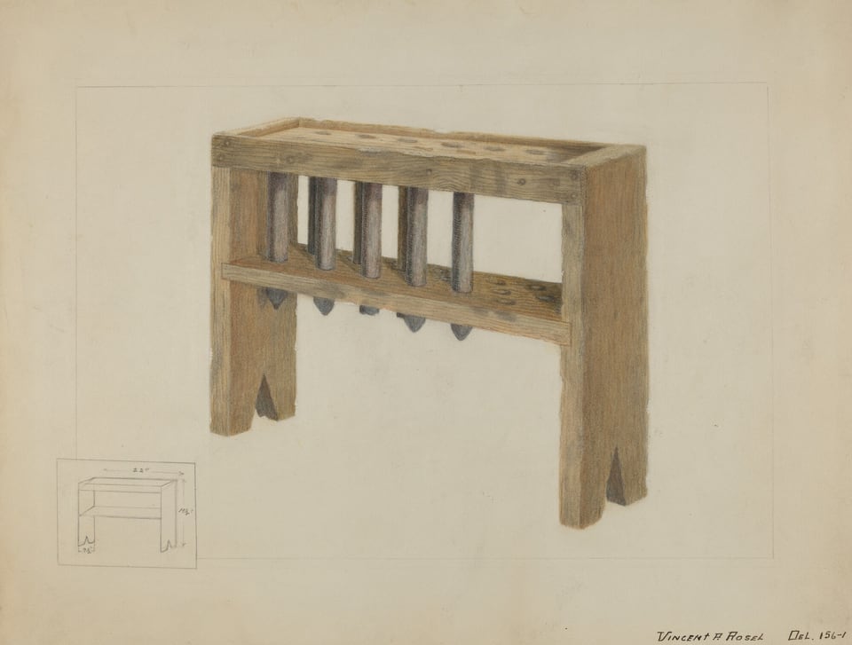 The image shows a wooden frame with six vertical cylindrical pegs evenly spaced. The color palette consists of light and medium brown tones. The structure is angled to the right with four visible legs. In the bottom left corner, there is a smaller sketched diagram with measurements.