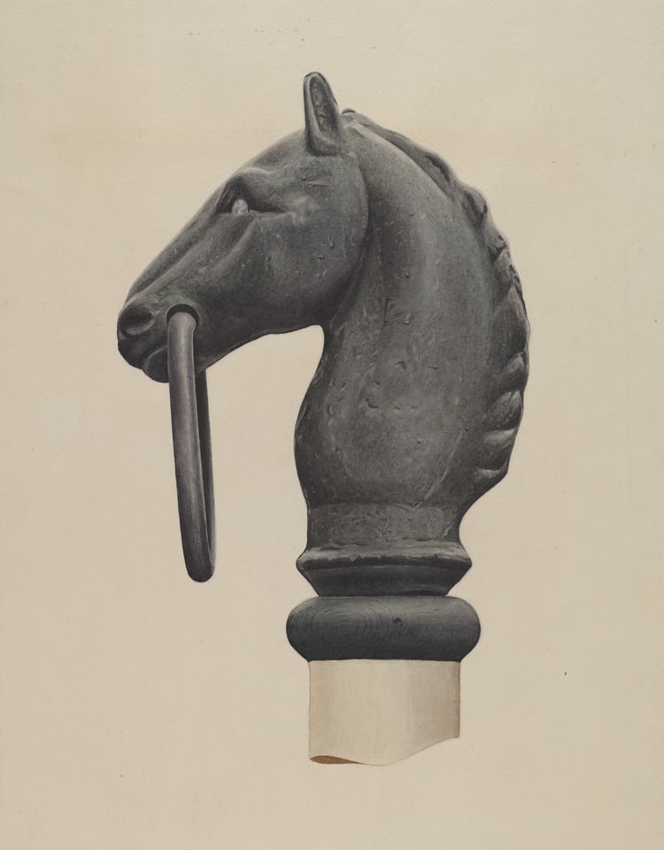 The sculpture is a depiction of a horse's head crafted from a dark material that appears to be metal. The horse's ears are perked up, and its mane is depicted with smooth, curving lines trailing down the back of the neck. The sculpture includes a ring that extends from the horse's mouth. Positioned on a simple cylindrical pedestal, the sculpture's material and design suggest a robust and timeless feel. The details of the horse's expression and mane are rendered with a smooth finish.